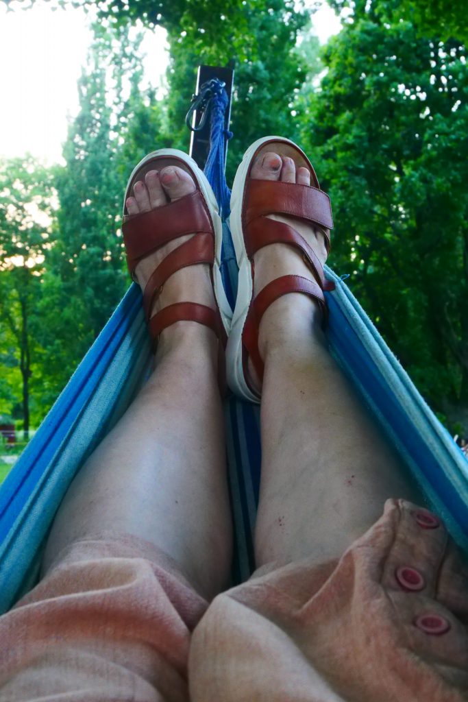 Beine und Füße mit Sandalen in einer Hängematte