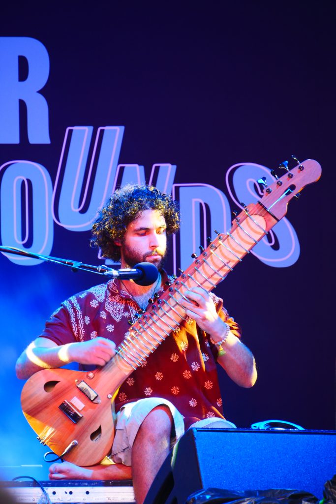 Ein Künstler spielt auf der Bühne auf einer Sitar